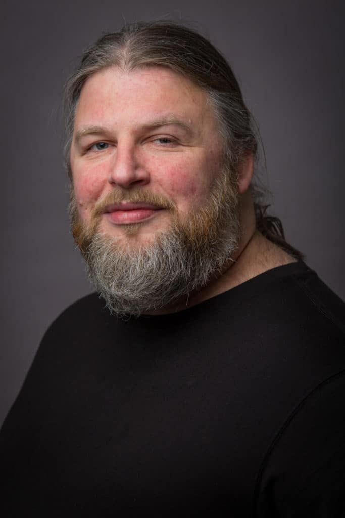 Photo of Jeremy Shirland, guitar, bass, and uke music teacher, wearing a black shirt.