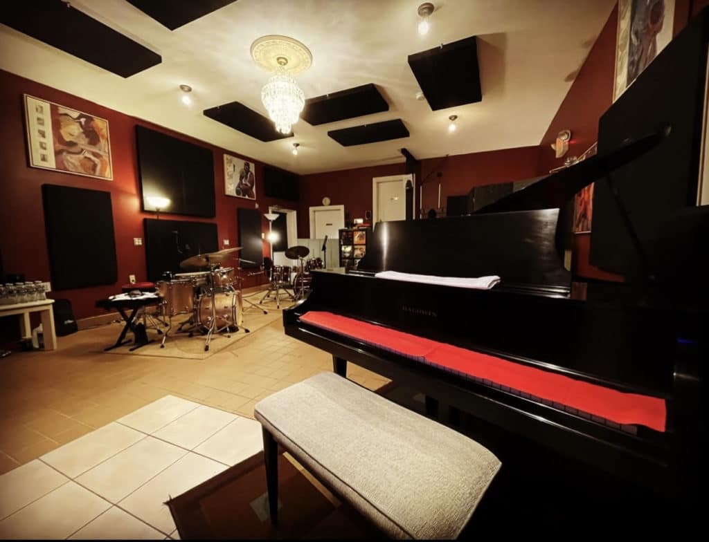 Recording Studio live room with drum set, grand piano, acoustic padding, and other instruments